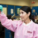 Woman looking at lab vial"